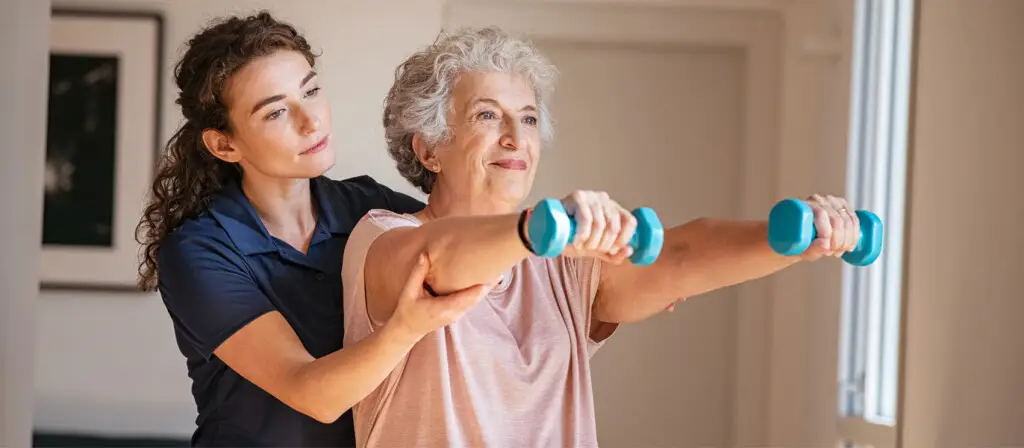 Physical Therapy Patient with weights and health care worker