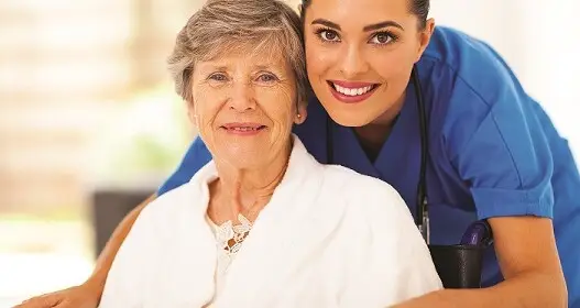 hospice nurse with elderly woman smiling