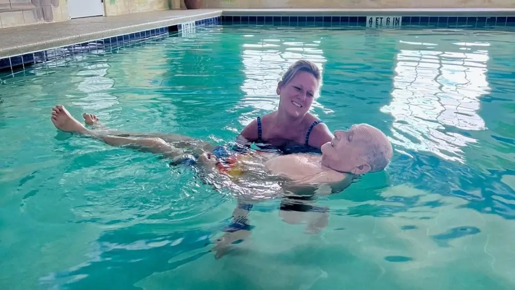 Robert Small with nurse floating in swimimng pool